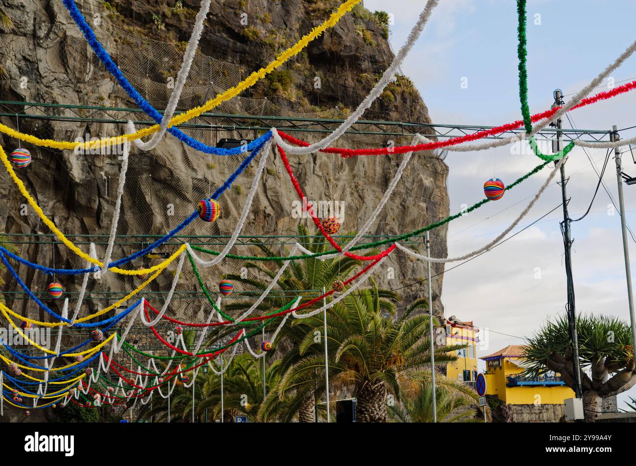 Les décorations colorées du festival sont suspendues dans les airs avec pour toile de fond les falaises et les palmiers à ponta do sol Banque D'Images