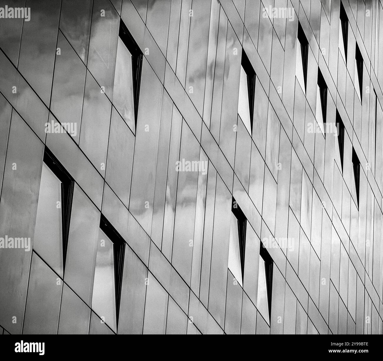 Formes abstraites causées par des fenêtres ouvertes sur un immeuble de bureaux à façade en verre sur le front de la rivière Liverpool, Royaume-Uni - Image de stock capturée avec un smartphone