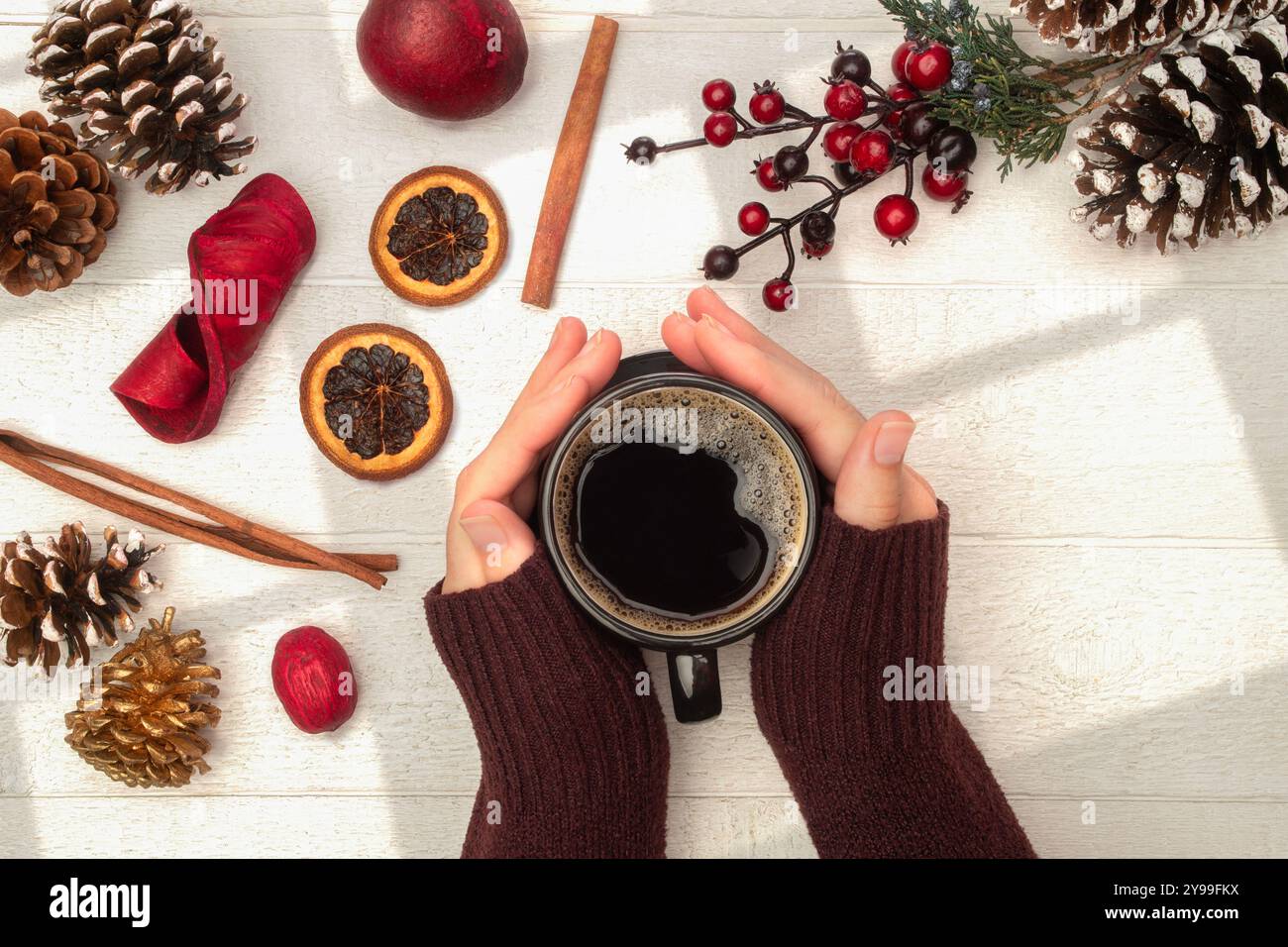 Mains tenant le café avec le pull tiré sur et le thème de Noël Banque D'Images