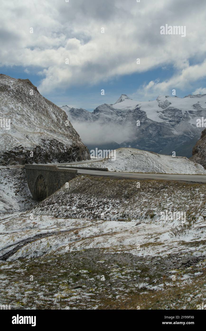 Vue panoramique sur le col de l'iséran en France, avec des sommets enneigés, une route sinueuse et des paysages alpins spectaculaires Banque D'Images