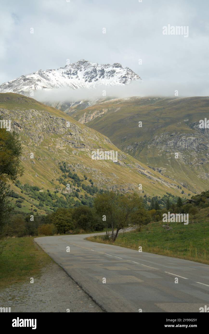 Route sinueuse sur le col de l'iséran, avec des sommets enneigés et un paysage alpin pittoresque. Banque D'Images