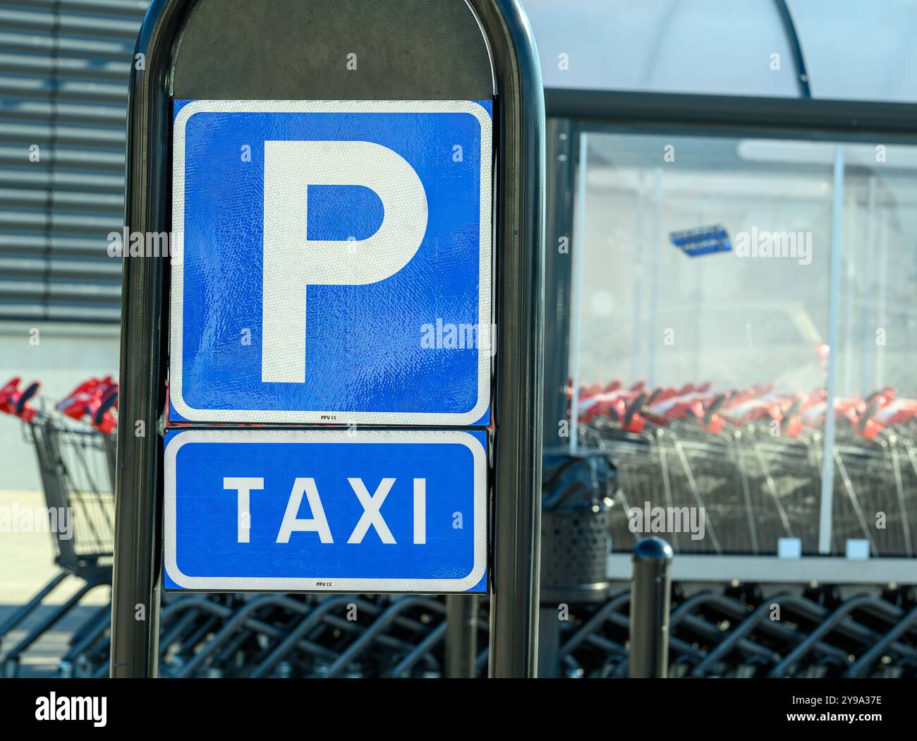 Un panneau de stationnement de taxi clair est affiché en évidence à côté d'une rangée de chariots dans un centre de vente au détail. Le cadre bénéficie d'une lumière du soleil éclatante et d'organiz Banque D'Images