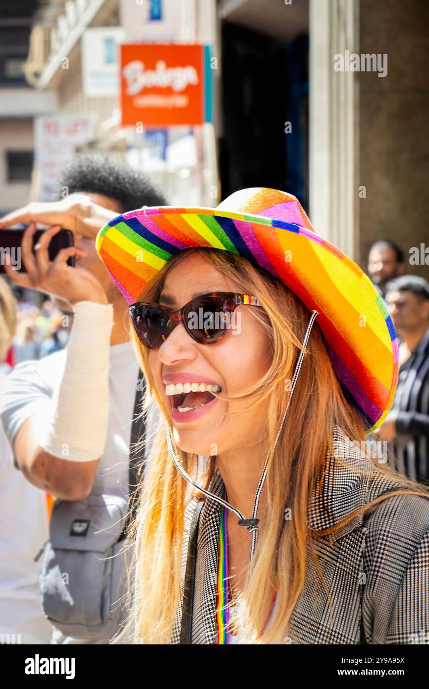 Riant jeune femme à Pride Birmingham portant un chapeau couleur arc-en-ciel et des lunettes de soleil Banque D'Images