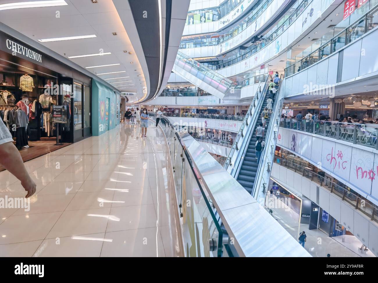 Hong Kong, Chine, 08 octobre 2024 : intérieur d'un centre commercial avec escaliers roulants, magasins et gens marchant. Banque D'Images