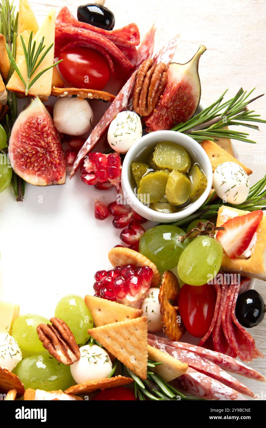 Couronne de Noël de collations festives. Canapés au fromage avec légumes et salami sur fond blanc. Couronne de nourriture de Noël. Vue de dessus. Banque D'Images Couronne de Noël de collations festives. Canapés au fromage avec légumes et salami sur fond blanc. Couronne de nourriture de Noël. Vue de dessus. Banque D'Images