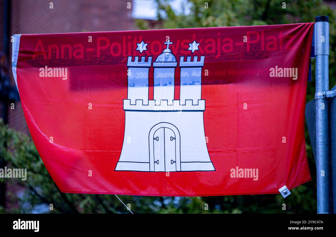 Hambourg, Allemagne. 10 octobre 2024. Un panneau de rue enveloppé dans un drapeau de Hambourg pointe vers la place Anna Politkovskaya. La journaliste russe Anna Politkovskaïa a été assassinée devant son appartement à Moscou le 7 octobre 2006. Dans son travail, Politkovskaïa a critiqué ouvertement et à maintes reprises le régime russe, par exemple dans le cadre de la guerre en Tchétchénie. Crédit : Axel Heimken/dpa/Alamy Live News Banque D'Images