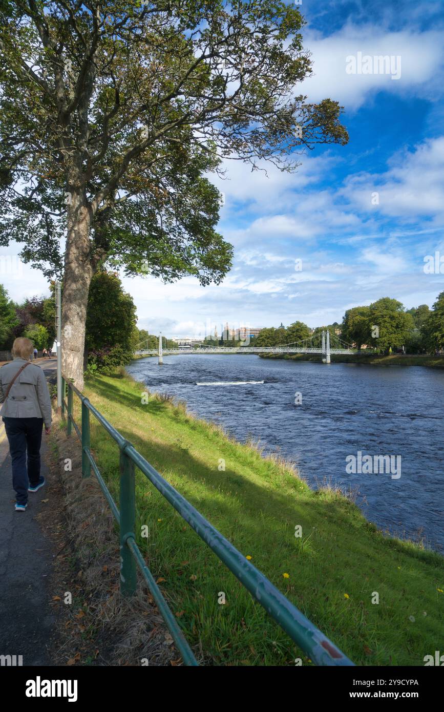 Regardant de l'autre côté de la rivière Ness et descendant vers le centre d'Inverness. Montrant les gens traversant un pont à maillons de chaîne blancs à River Ness Island Walk, le célèbre Banque D'Images