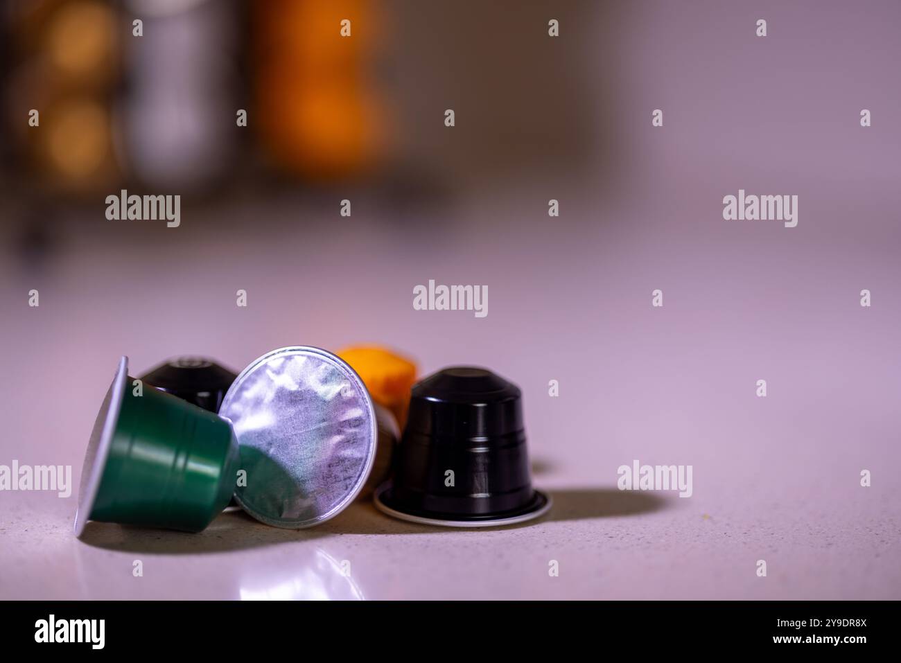 Une sélection de capsules de café se trouve sur la table, avec un organisateur de capsules de café visible derrière, ajoutant une touche organisée et élégante Banque D'Images