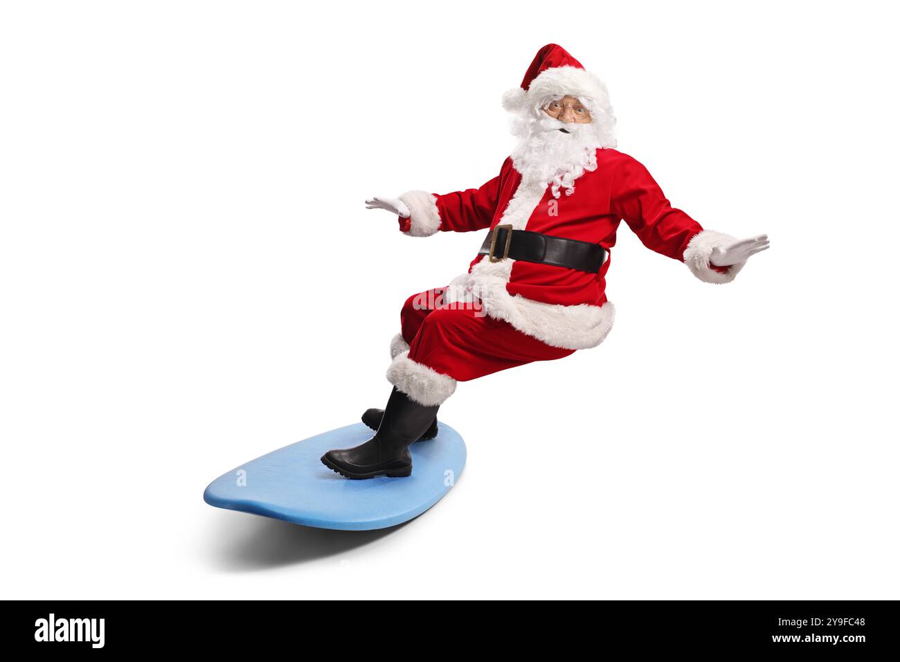 Père noël chevauchant une planche de surf isolé sur fond blanc Banque D'Images
