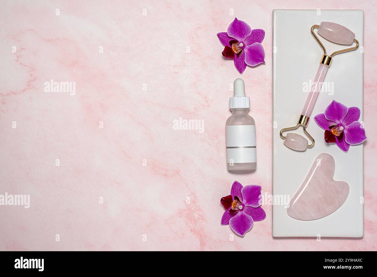 Photographie vierge de gua Sha de quartz rose et rouleau facial, massage anti-âge, lifting du visage, sérum facial ; acide hyaluronique; hydratant, lotion, cleansin Banque D'Images