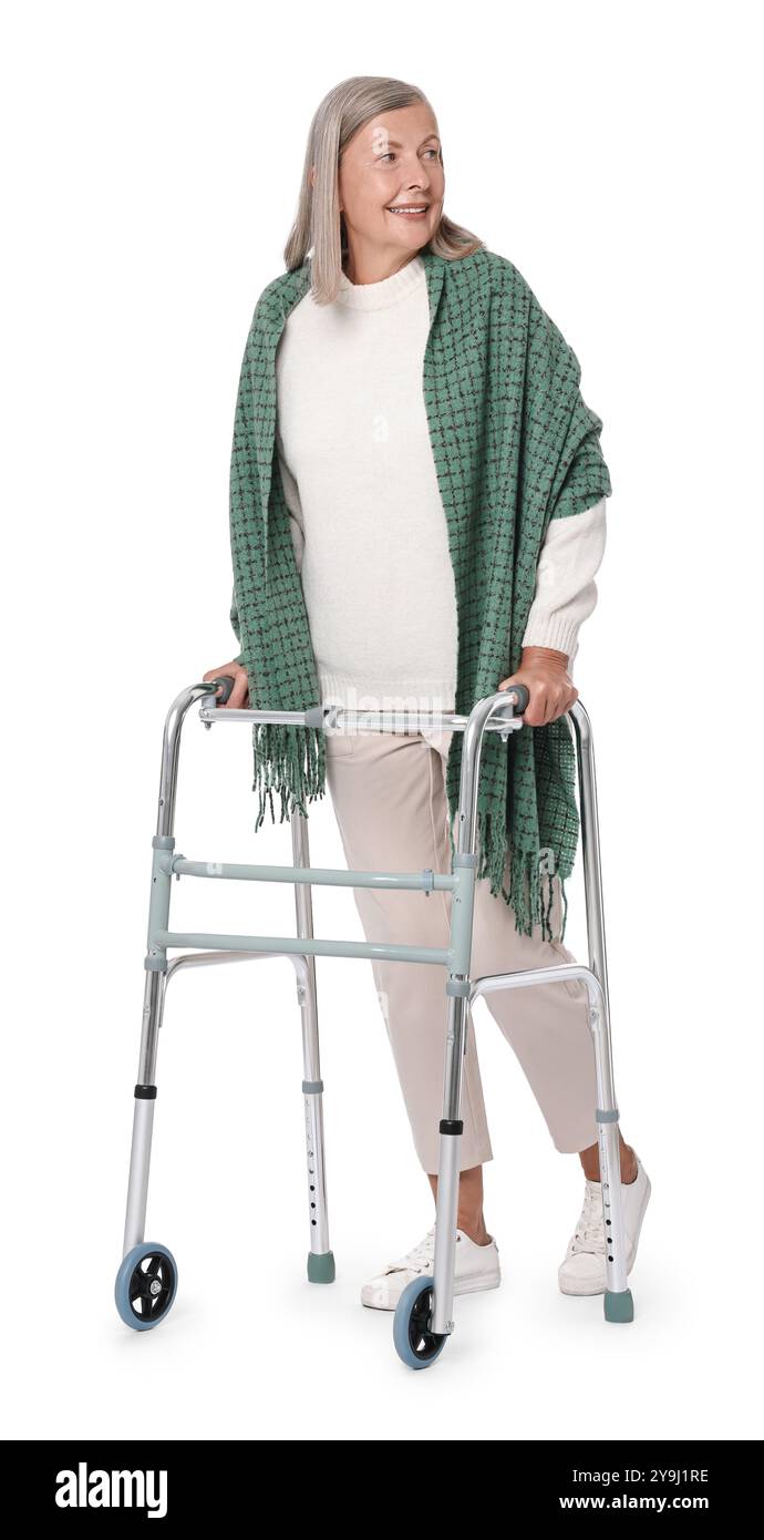 Femme senior utilisant le cadre de marche sur fond blanc Banque D'Images