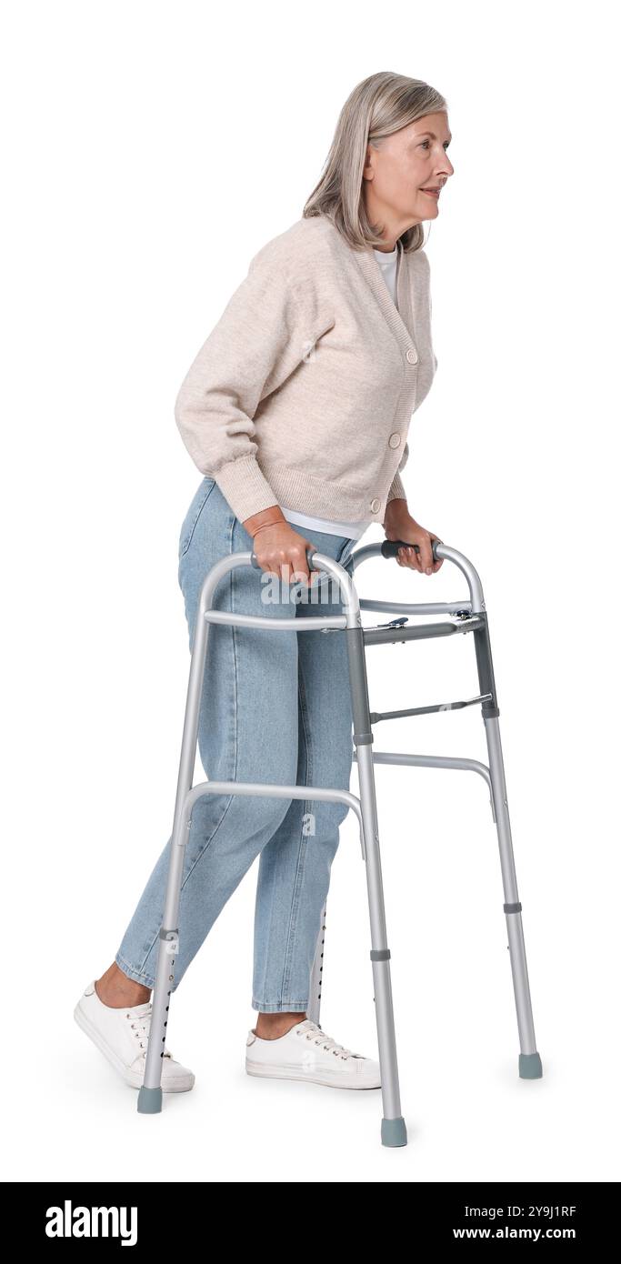 Femme senior utilisant le cadre de marche sur fond blanc Banque D'Images