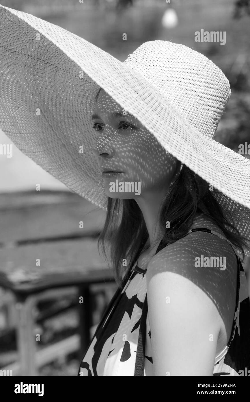 Photo de tête extérieure d'une femme portant un chapeau de paille à large bord Banque D'Images