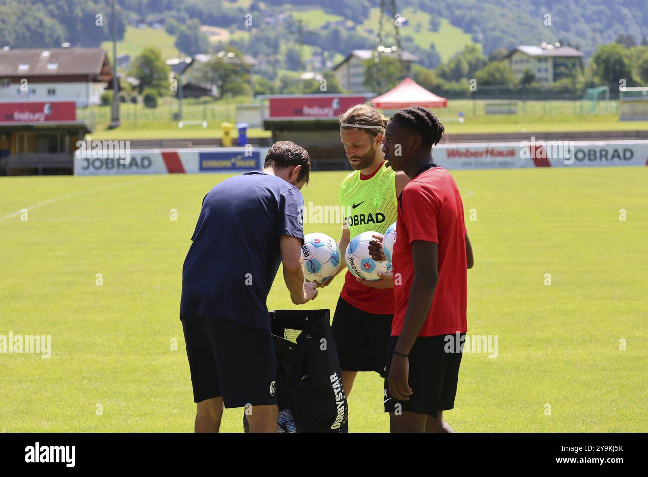 L'entraîneur Julian Schuster (SC Freiburg) illustre l'esprit d'équipe et aide Lucas Hoeler (SC Freiburg) et Johan Manzambi (SC Freiburg) à collecter les balles après Banque D'Images