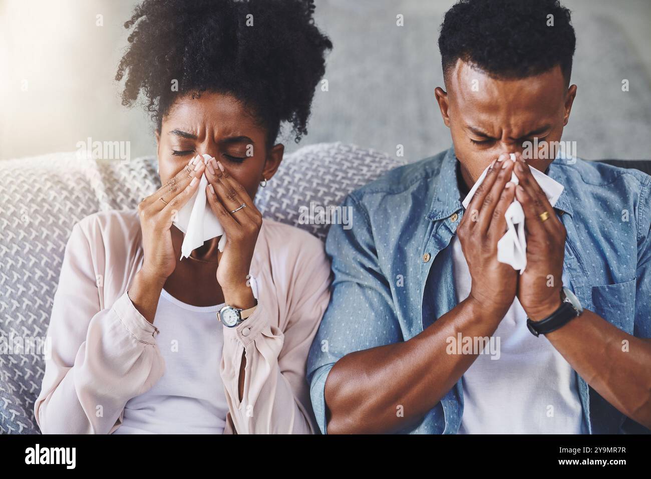 Grippe, canapé et couple noir avec du tissu à la maison pour les allergies, le rhume des foins et l'infection. Datant, maison et homme et femme avec mouchoir soufflant le nez Banque D'Images