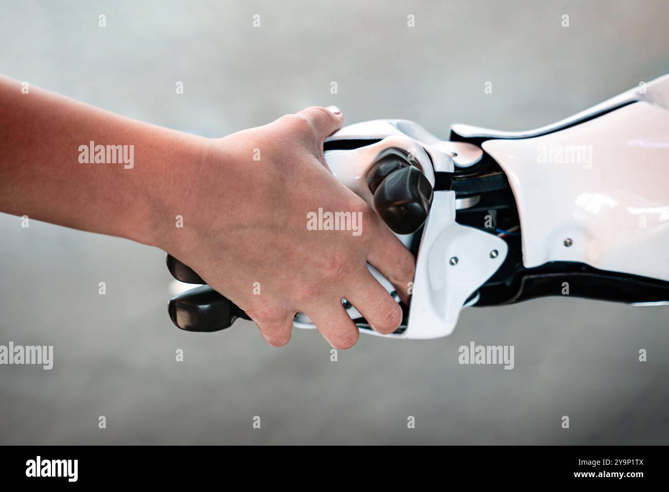 Concept de conception de communication cybernétique. Robot et homme féminin tenant les mains avec poignée de main. Banque D'Images