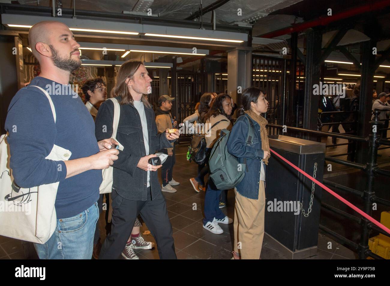 New York, États-Unis. 10 octobre 2024. Les navetteurs regardent la conférence de presse sur la sécurité du métro et les services sociaux du maire Adams à l'intérieur de la station de métro Times Square 42nd Street dans le centre de Manhattan. Le maire Adams a annoncé l'initiative PATH, un effort multi-agences impliquant le NYPD, le Département des services aux sans-abri et des travailleurs de la santé, utilisant un modèle de «co-réponse» pour répondre à la fois aux besoins de sécurité et de santé mentale pour aider plus de New-Yorkais. Crédit : SOPA images Limited/Alamy Live News Banque D'Images