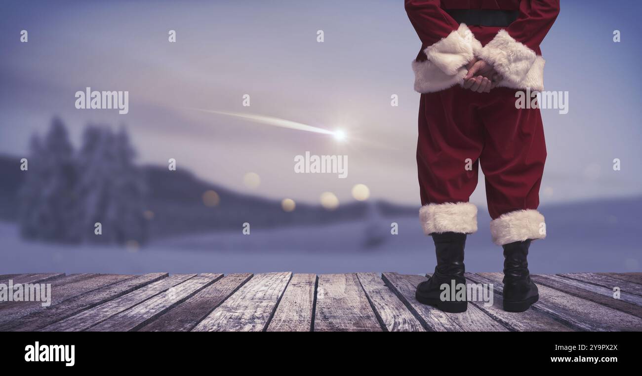 Santa Claus debout et regardant le paysage hivernal avec étoile filante dans le ciel, Noël et concept de bonne année, espace de copie Banque D'Images