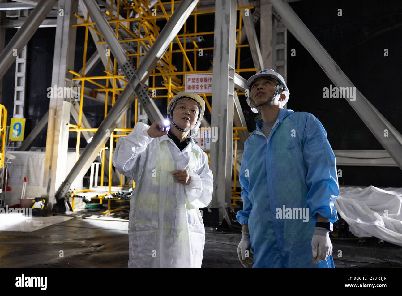 (241011) -- JIANGMEN, Oct. 11, 2024 (Xinhua) -- ma Xiaoyan (l) s'entretient avec un membre du personnel au fond du réservoir d'eau du détecteur central de l'Observatoire souterrain de neutrinos de Jiangmen (JUNO) à Jiangmen, dans la province du Guangdong du sud de la Chine, Oct. 10, 2024. La Chine a construit le plus grand détecteur sphérique transparent du monde à 700 mètres sous terre pour capturer des neutrinos insaisissables, souvent surnommés « particules fantômes », afin de percer les secrets de l'infiniment petit et de l'infiniment vaste de l'univers. La sphère acrylique de 12 étages avec un diamètre de 35,4 mètres, enfouie profondément dans un gr Banque D'Images