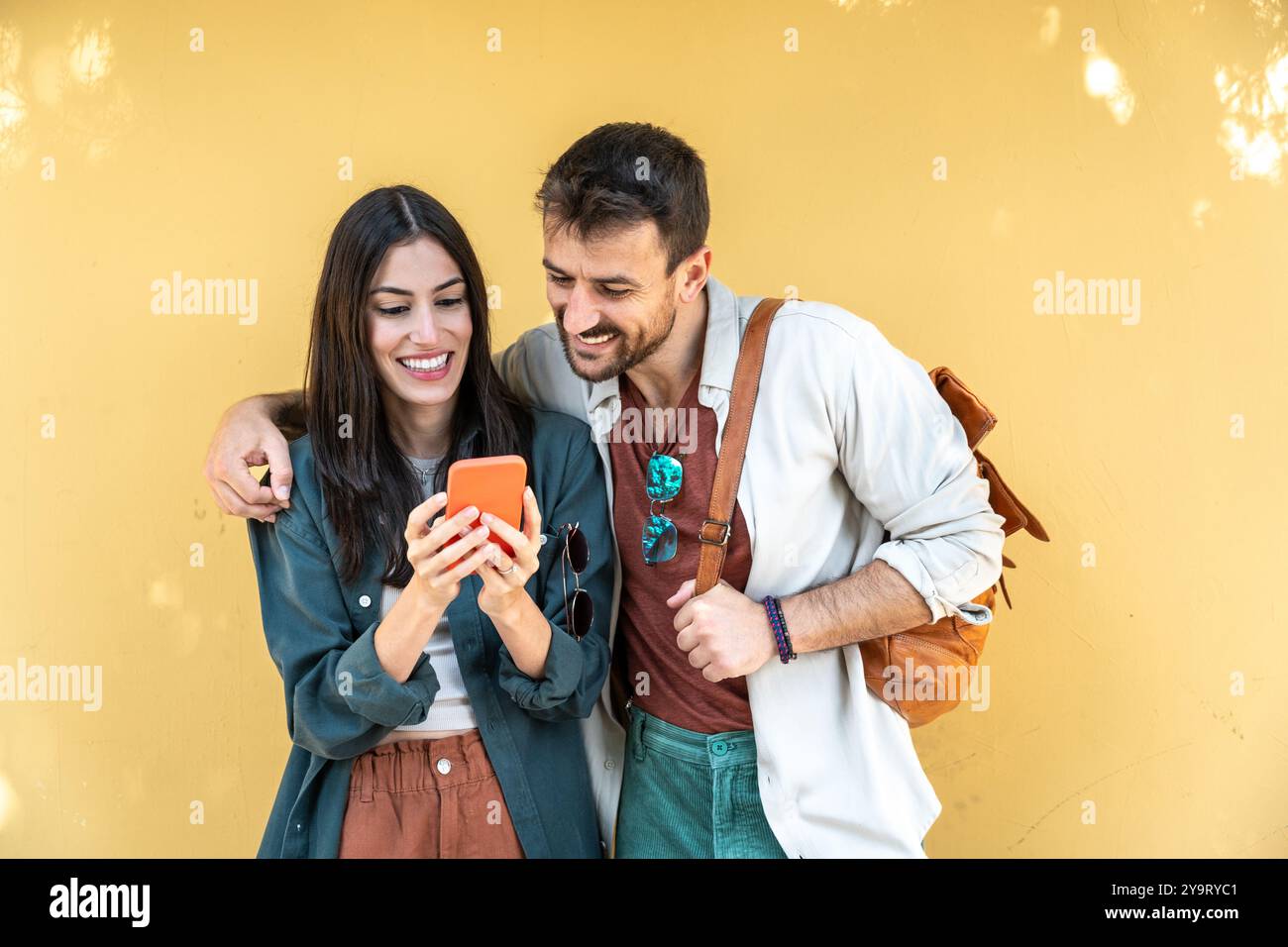 Deux personnes, jeune beau couple millennial hipster à la mode à la recherche de la direction de la carte sur leur téléphone intelligent. Touristes dans des vêtements frais debout ag Banque D'Images
