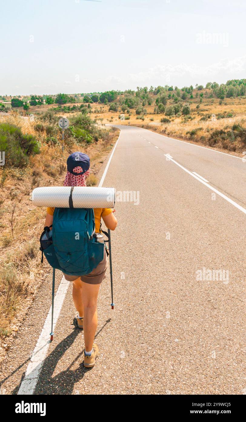 Un pèlerin marchant le long d'une route rurale sur le Camino de Santiago. Espagne. Banque D'Images