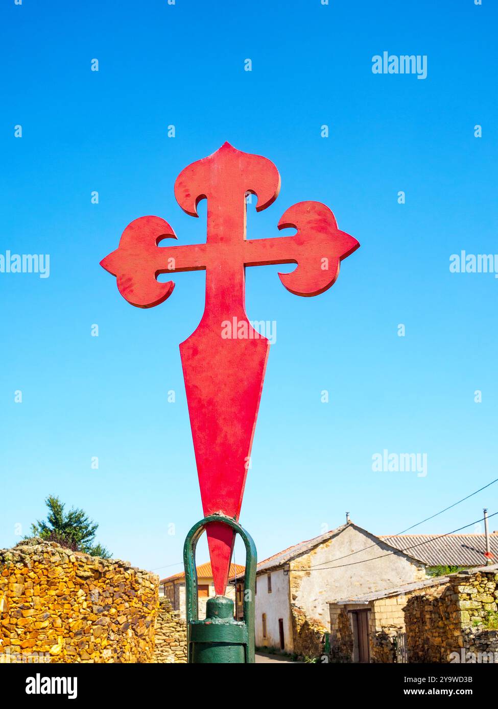 La grande Croix rouge de Saint James se dresse bien en évidence contre un ciel bleu clair dans un village rural espagnol. Espagne. Banque D'Images