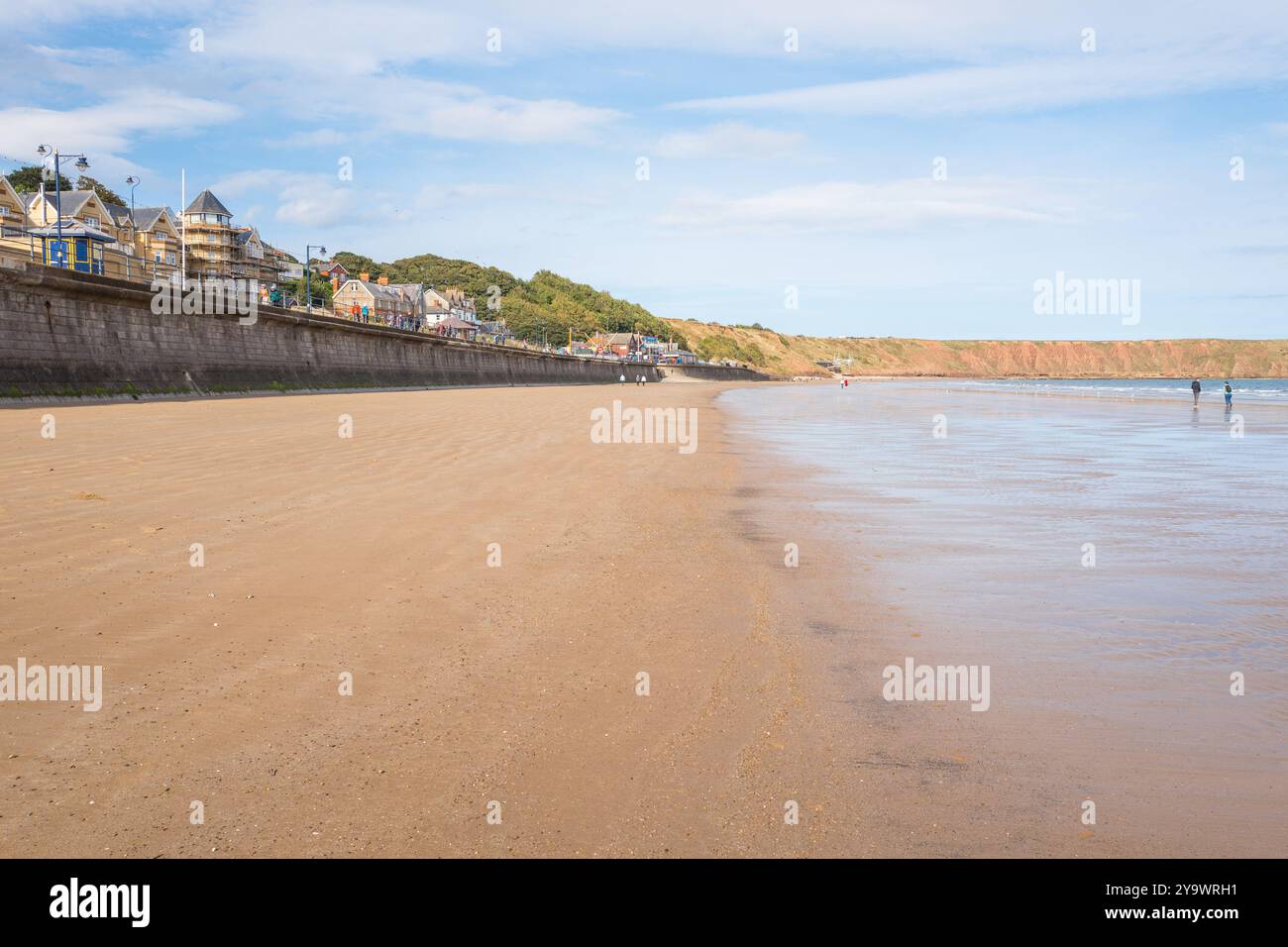 La plage de sable et la digue de la ville balnéaire de Filey, North Yorkshire, Angleterre, Royaume-Uni, à marée basse. Banque D'Images
