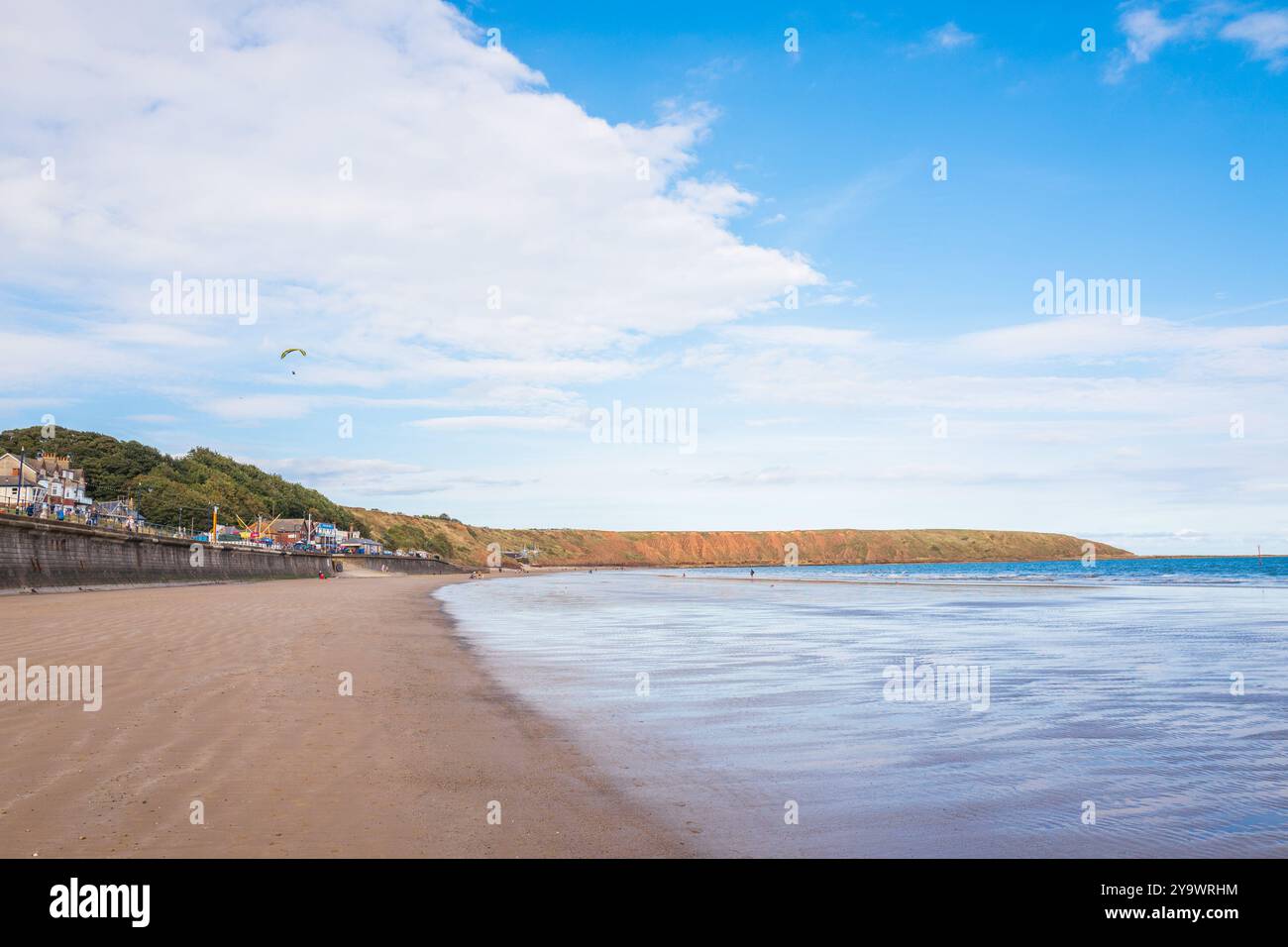 La plage de sable et la digue de la ville balnéaire de Filey, North Yorkshire, Angleterre, Royaume-Uni, à marée basse. Banque D'Images