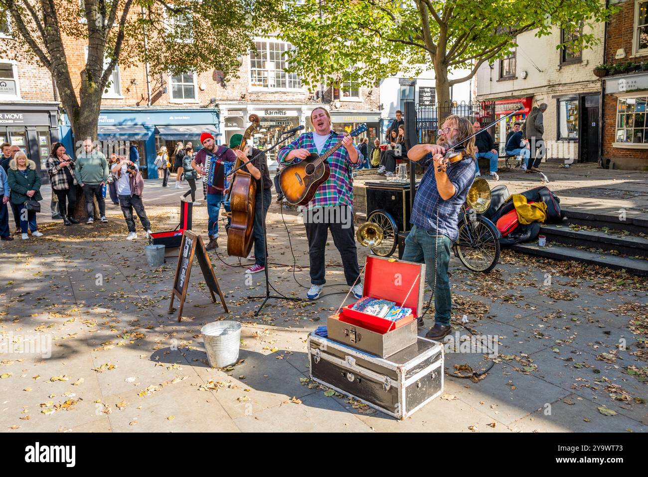 Le groupe de quatre musiciens Hyde Family Jam Busking en direct devant un public passant dans le centre-ville de york, Yorkshire, Angleterre. Banque D'Images