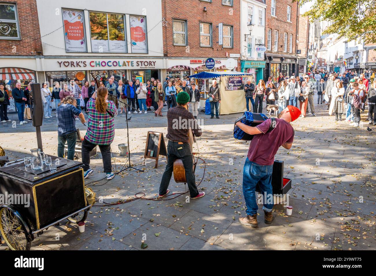 Le groupe de quatre musiciens Hyde Family Jam Busking en direct devant un public passant dans le centre-ville de york, Yorkshire, Angleterre. Banque D'Images