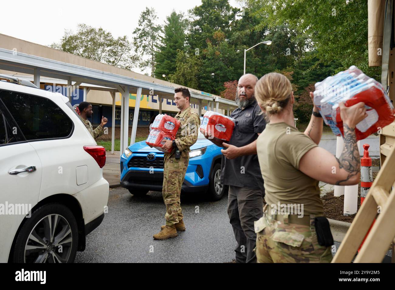 Hot Springs, États-Unis. 29 septembre 2024. Les soldats de l'armée américaine avec la Task Force Panther, aux côtés de volontaires civils distribuent de la nourriture et des MRE aux survivants à la suite de l'ouragan Helene à l'école primaire William W. Estes, le 30 septembre 2024 à Asheville, Caroline du Nord. Crédit : Madeleine Cook/FEMA photo/Alamy Live News Banque D'Images