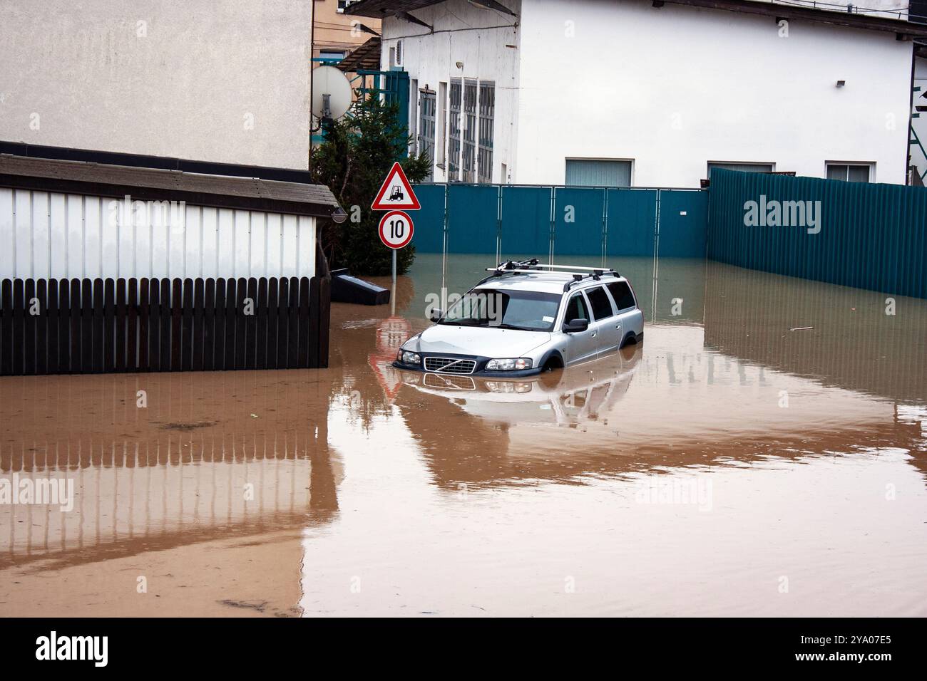 Voiture sous l'eau brune d'inondation dans la stree inondée dans la zone de banlieue Banque D'Images