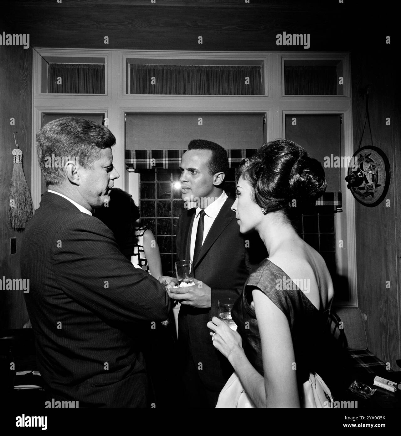 Le président américain John F. Kennedy discutant avec le chanteur Harry Belafonte et Julie Robinson Belafonte lors de la réception à la résidence d'Arthur B. Krim et Dr Mathilde Krim, New York City, New York, États-Unis, Cecil Stoughton, White House Photographs, 19 mai 1962 Banque D'Images