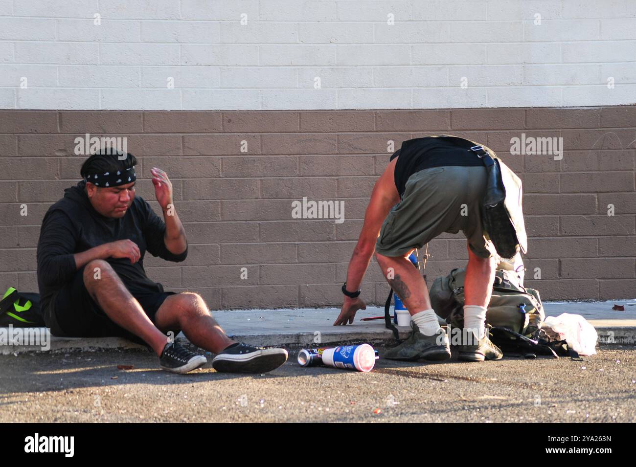 Tempe, Arizona, États-Unis. 11 octobre 2024. Deux individus non abrités partagent l'espace à l'extérieur d'un dépanneur sur une rue Tempe alors que les températures de l'après-midi atteignent 102Â°F. Phoenix Metro est confronté aux effets de la chaleur d'octobre intensément saisonnière, touchant les piétons, les policiers à vélo, ceux qui cherchent un abri et les navetteurs qui dépendent du transport en commun. Avec des températures dépassant 100Â°F, les résidents sont confrontés à des risques élevés liés à la chaleur dans les routines quotidiennes. (Crédit image : © Eduardo Barraza/ZUMA Press Wire) USAGE ÉDITORIAL SEULEMENT! Non destiné à UN USAGE commercial ! Banque D'Images