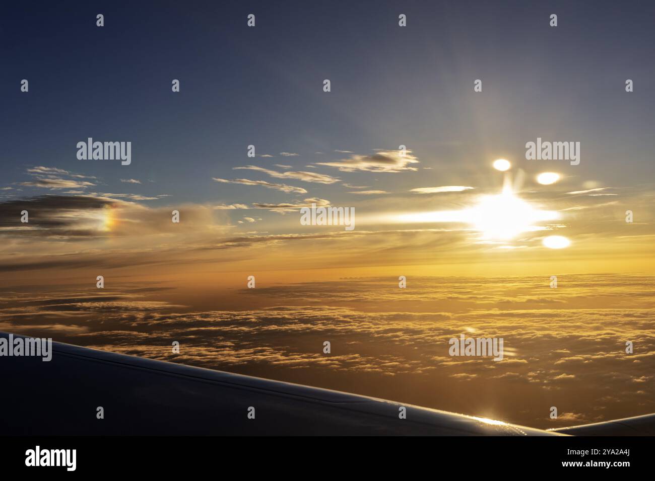 Vue en avion du coucher de soleil radieux sur les nuages avec des rayons intenses de lumière, vol, photographie aérienne Banque D'Images