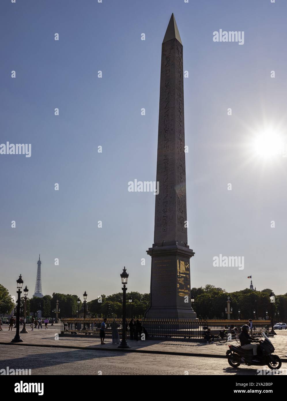 Rayons de soleil derrière un obélisque, Tour Eiffel en arrière-plan, moto de passage, Paris Banque D'Images