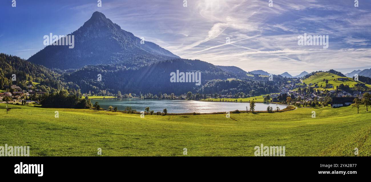 Pittoresque scène alpine avec un lac entouré de prairies verdoyantes et de montagnes sous un ciel bleu clair, Thiersee, Autriche, Europe Banque D'Images