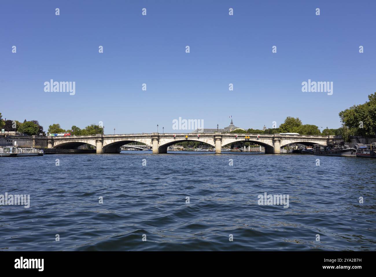 Pont sur une rivière sous un ciel bleu clair dans un environnement urbain, Paris Banque D'Images