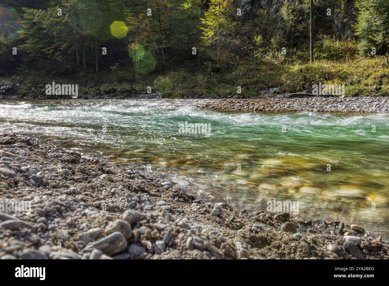 Une rivière coule devant une toile de fond montagneuse illuminée par les rayons du soleil, Klobenstein Banque D'Images