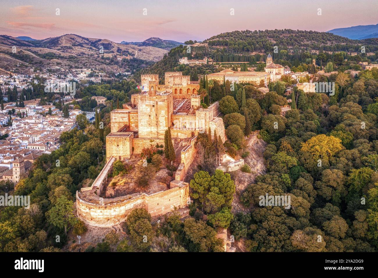 Vue aérienne d'une Alhambra entourée d'arbres au coucher du soleil en terrain vallonné, Grenade Banque D'Images Vue aérienne d'une Alhambra entourée d'arbres au coucher du soleil en terrain vallonné, Grenade Banque D'Images