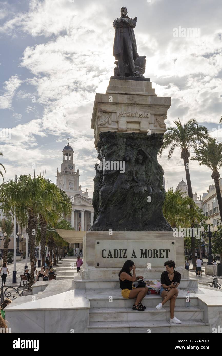 Grande statue avec des gens, entourée de palmiers et d'architecture historique, Cadix Banque D'Images Grande statue avec des gens, entourée de palmiers et d'architecture historique, Cadix Banque D'Images