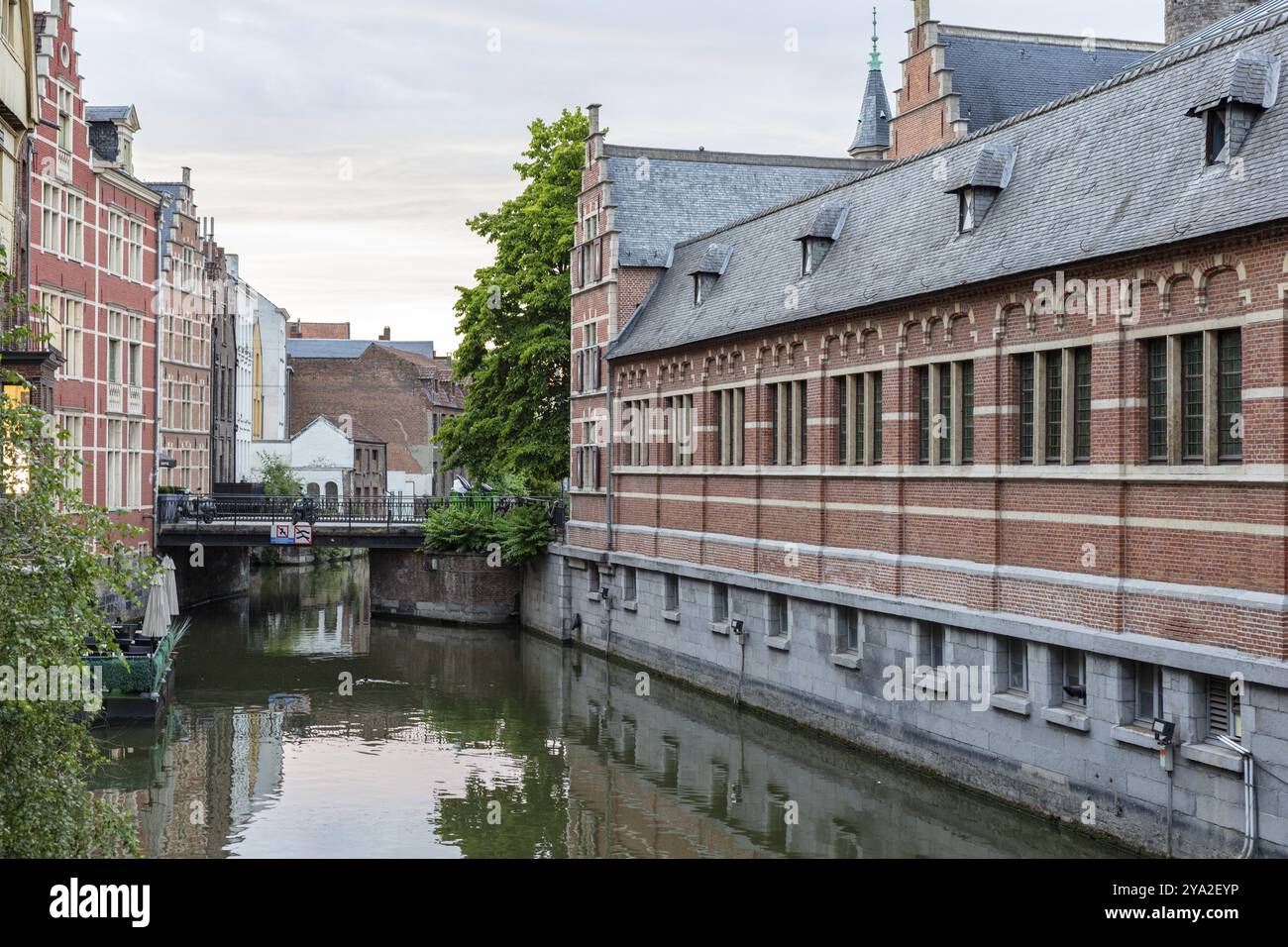 Vue sur le canal urbain avec des bâtiments historiques en briques et une voie navigable tranquille, Gand Banque D'Images