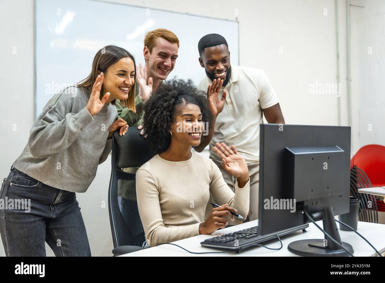 Équipe de divers collègues agitant à l'écran lors d'une réunion en ligne ensemble dans le bureau Banque D'Images