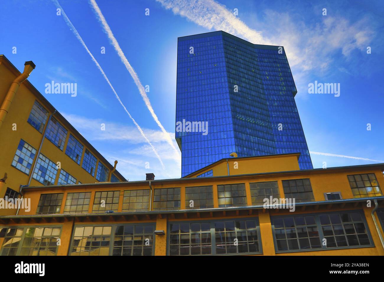 Gratte-ciel moderne avec verre réfléchissant à côté d'un vieux bâtiment en briques jaunes sous un ciel bleu clair avec des traînées, Prime Tower, Zurich, Canton de Z Banque D'Images