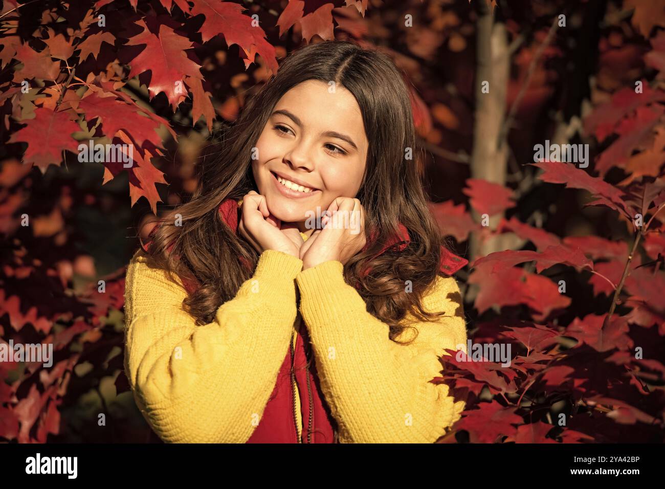 Visage de fille d'automne sur fond de feuille d'automne. Automne enfant adolescent fille 12, 13, 14 ans portrait. Visage de l'enfant souriant debout à beau Banque D'Images