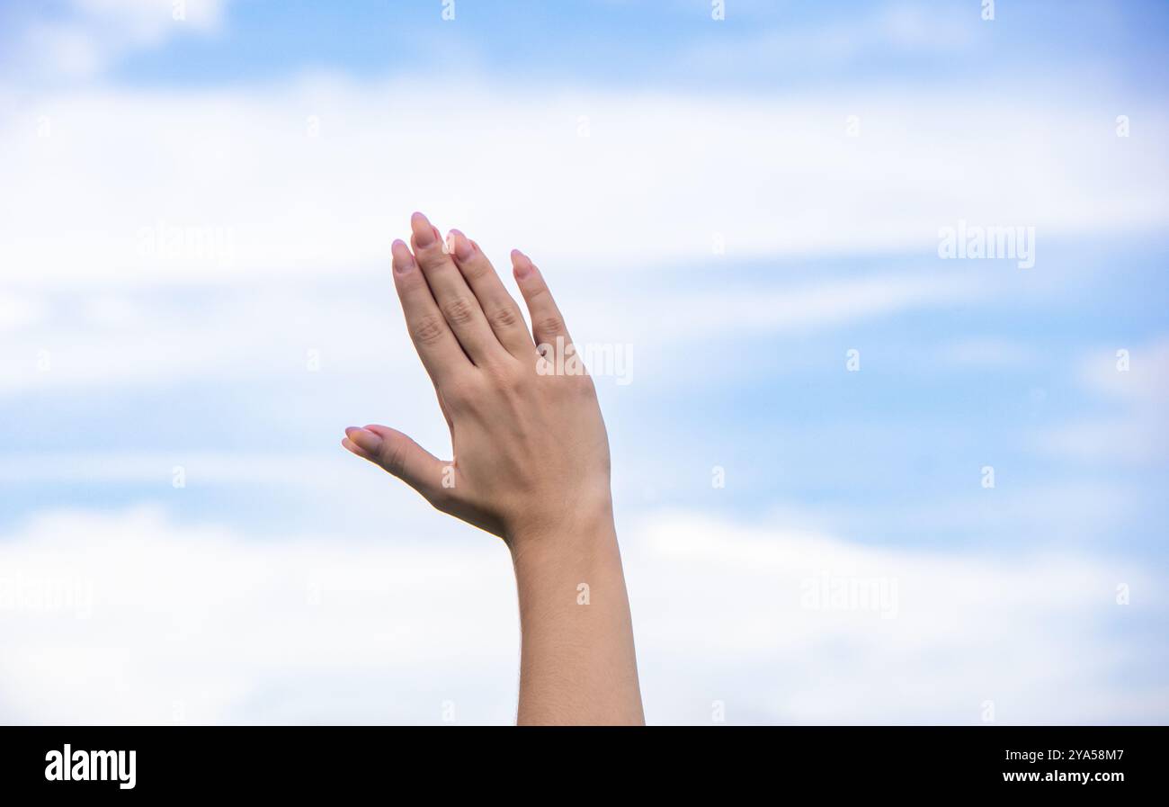 Belles et délicates mains ensemble d'une femme blanche avec une manucure faite avec un ciel bleu avec quelques nuages en arrière-plan à la fin d'un yoga pr Banque D'Images