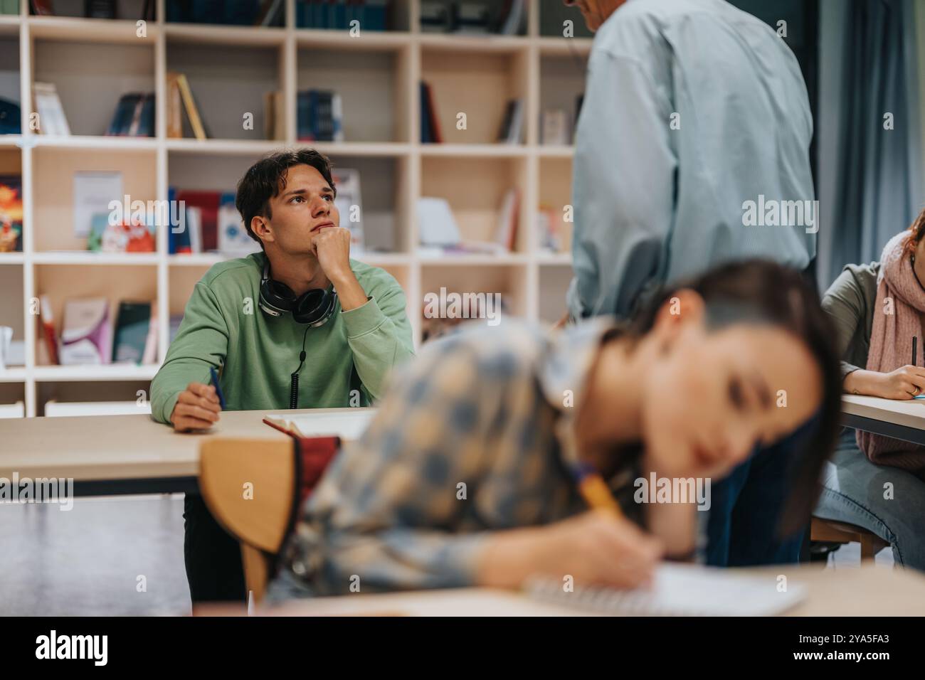 Les étudiants écoutent attentivement le professeur âgé en classe Banque D'Images