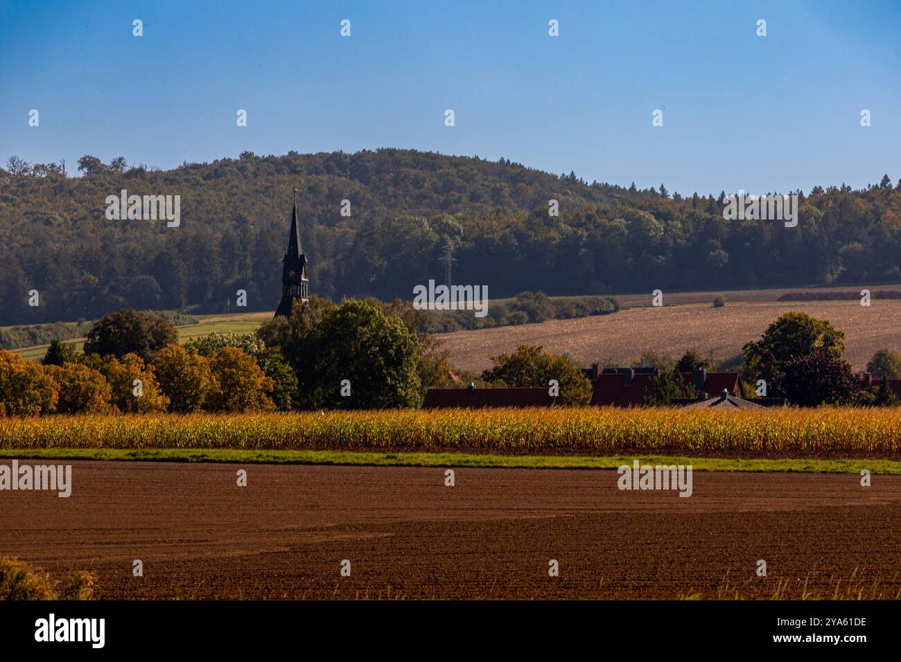 Panorama d'un paysage avec collines et village où la flèche de l'église dépasse. Photo de haute qualité Banque D'Images