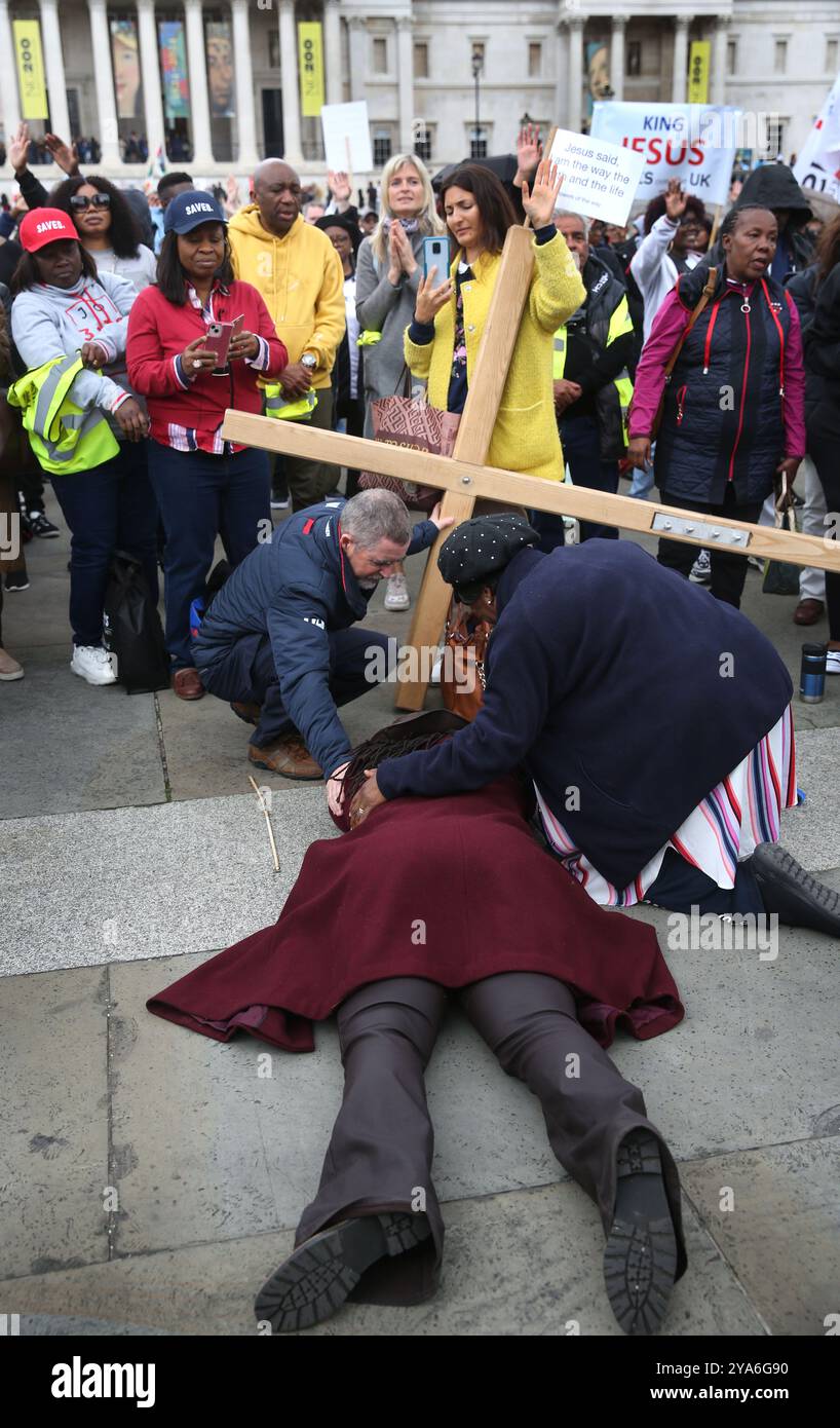 Londres, Angleterre, Royaume-Uni. 12 octobre 2024. Un partisan est couché sur le ventre devant une croix géante à Trafalgar Square dans un état presque en transe pendant le rallye. Les supporters se rassemblent à Westminster pour ''˜marcher pour Jésus'', célébrer leur foi et répandre l'amour et la positivité dans la communauté. Ils marchent, chantent et prient ensemble et partagent le message de Jésus avec tout le monde autour. Ils argumentent avec tous les troubles dans le monde actuellement que trouver Jésus est la réponse. (Crédit image : © Martin Pope/ZUMA Press Wire) USAGE ÉDITORIAL SEULEMENT! Non destiné à UN USAGE commercial ! Banque D'Images