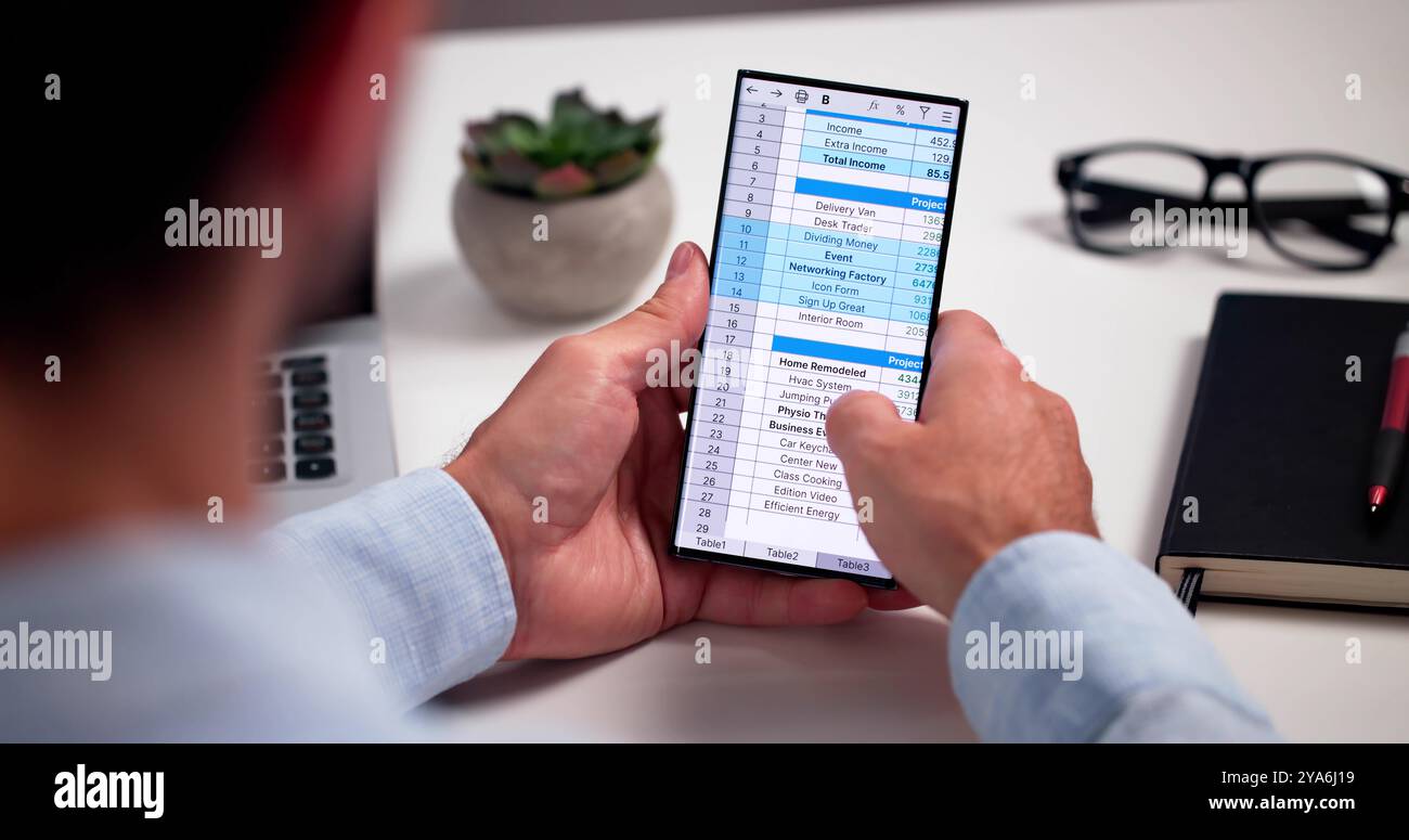 Analyste de données de feuille de calcul utilisant un logiciel informatique sur téléphone Banque D'Images